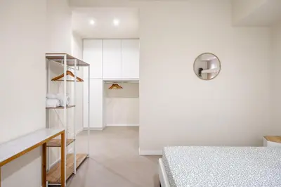 a white bedroom with a bed and a closet at Maison169 in Palermo