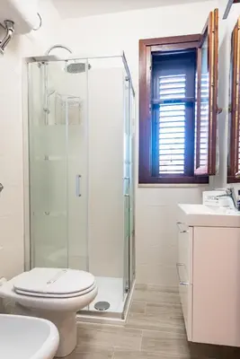 a bathroom with a shower and a toilet and a sink at Villa Diamante in Campofelice di Roccella