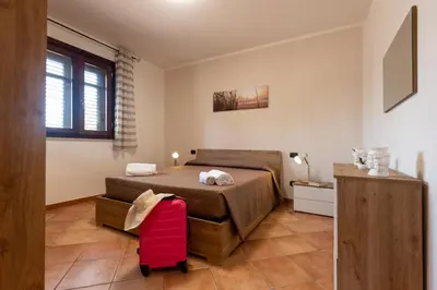 a bedroom with a bed and a red suitcase at Villa Diamante in Campofelice di Roccella