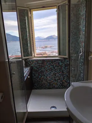 a bathroom with a shower and a sink and two windows at Il Balcone sul mare - free parking & relax in Palermo