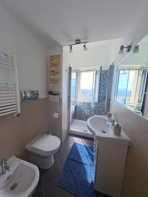 a bathroom with two sinks and a toilet and a shower at Il Balcone sul mare - free parking & relax in Palermo