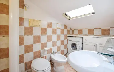 a bathroom with a toilet sink and a washing machine at Awesome Apartment In Trabia in Trabia