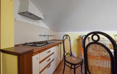 a small kitchen with a stove and two chairs at Awesome Apartment In Trabia in Trabia