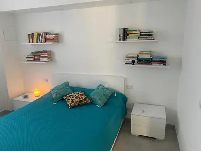 a bedroom with a blue bed with two pillows at Appartamento Florio in Palermo