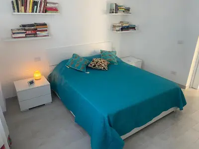 a bedroom with a blue bed and a night stand at Appartamento Florio in Palermo