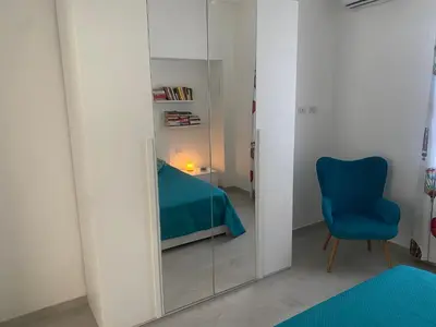 a room with a mirror and a blue chair at Appartamento Florio in Palermo