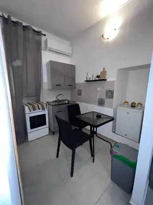 a small kitchen with a table and a dining room at LION'S Room in Palermo