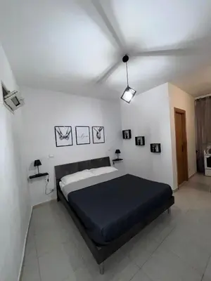 a bedroom with a large bed in a white room at LION'S Room in Palermo