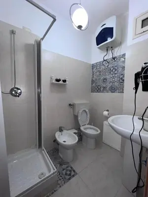 a bathroom with a shower and a toilet and a sink at LION'S Room in Palermo