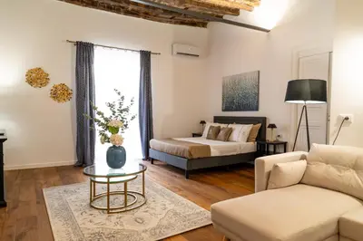 a living room with a bed and a couch at La Duca Suites & Apartments in Palermo