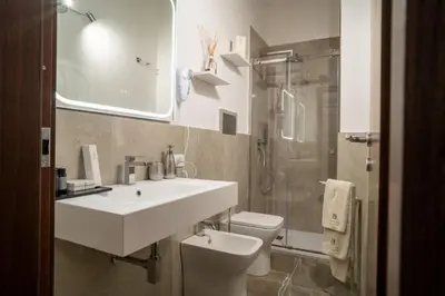 a bathroom with a sink and a toilet and a shower at La Duca Suites & Apartments in Palermo