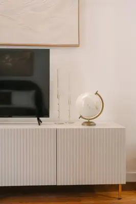 a white table with a tv and a globe on it at La Duca Suites & Apartments in Palermo