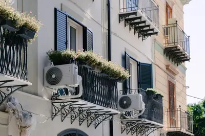 a building with balconies and flower boxes on it at La Duca Suites & Apartments in Palermo