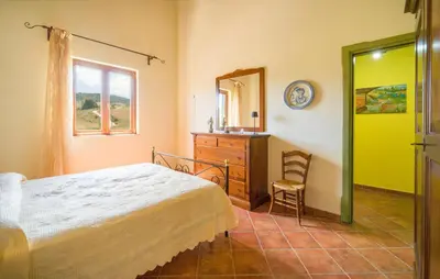 a bedroom with a bed and a dresser and a mirror at Awesome Home In Palazzo Adriano in Palazzo Adriano