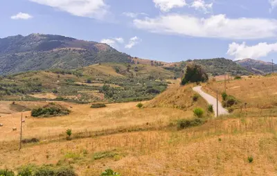 a winding road on a hill with mountains in the background at Awesome Home In Palazzo Adriano in Palazzo Adriano
