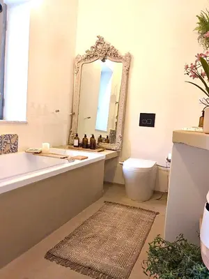 a bathroom with a tub and a toilet and a mirror at Dream Penthouse over main Square in Palermo