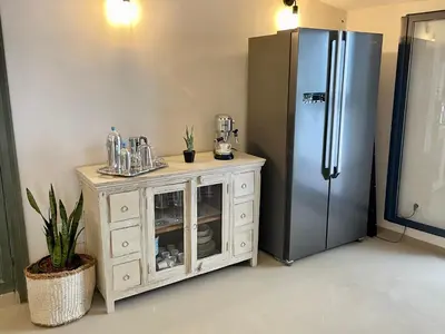 a kitchen with a refrigerator and a white dresser with a refrigeratorvelt at Dream Penthouse over main Square in Palermo