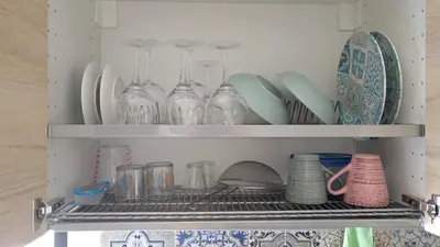 a shelf with glasses and plates and dishes on it at Virginia Holiday Home in Mondello