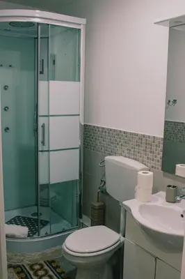a bathroom with a shower and a toilet and a sink at Mizzica Rooms in Palermo
