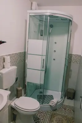 a bathroom with a glass shower and a toilet at Mizzica Rooms in Palermo