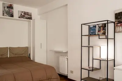 a bedroom with a bed and a book shelf at New Stabile APT Balcony central apartment in Palermo