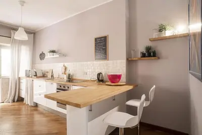 a kitchen with white cabinets and a wooden counter top at New Stabile APT Balcony central apartment in Palermo