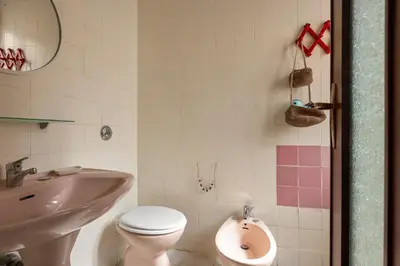 a bathroom with a white toilet and a sink at Casa Eugenia in Santa Flavia