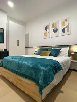 a bedroom with a large bed with a blue blanket at La casa di Alice in Palermo