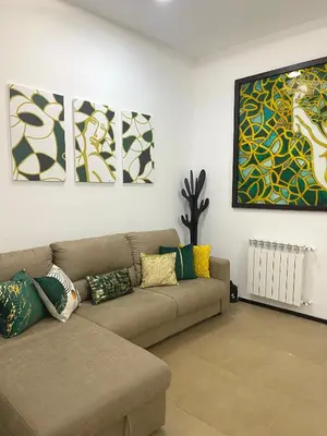 a living room with a couch and paintings on the wall at La casa di Alice in Palermo