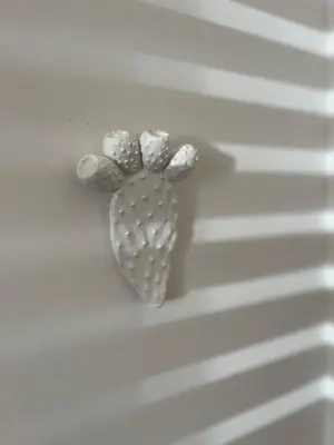 a silver heart shaped object on a white wall at Il Fico d'India in San Vito lo Capo
