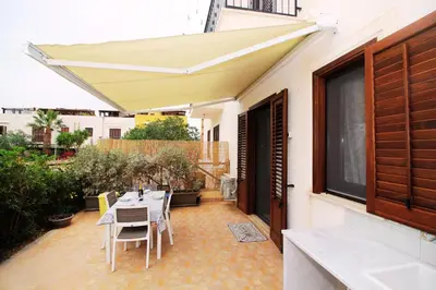 a patio with a table and chairs under an awning at Il Fico d'India in San Vito lo Capo