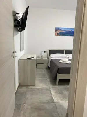 a bedroom with a bed and a television in it at San Vito Holiday Home in San Vito lo Capo