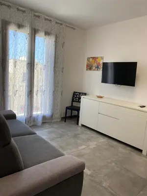 a living room with a couch and a flat screen tv at San Vito Holiday Home in San Vito lo Capo