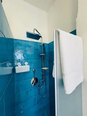a blue tiled bathroom with a shower in it at Sirio rooms and apartments in Carini