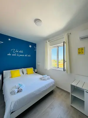 a bedroom with a large bed with a blue wall at Sirio rooms and apartments in Carini