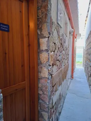 an entrance to a building with a stone wall and a wooden door at LA TERRAZZA SUL MARE camera vicino aereoporto&mare SICILIAN VINTAGE STYLE SEASIDE ROOM in Cinisi