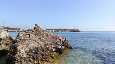 a large rock in the water next to the ocean at LA TERRAZZA SUL MARE camera vicino aereoporto&mare SICILIAN VINTAGE STYLE SEASIDE ROOM in Cinisi