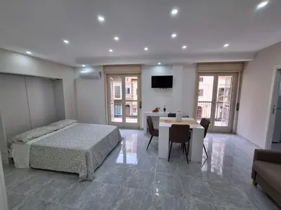 a bedroom with a bed and a table and a television at Casa cannella in Palermo