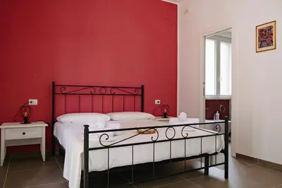 a bedroom with a red wall and a bed at Villa Rubino, Addaura - Mondello in Palermo