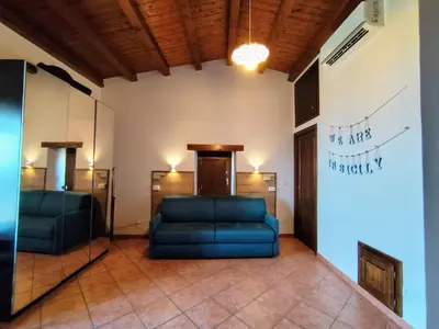 a room with a blue couch and a mirror at Open Space Marianna - Sea View in Trabia