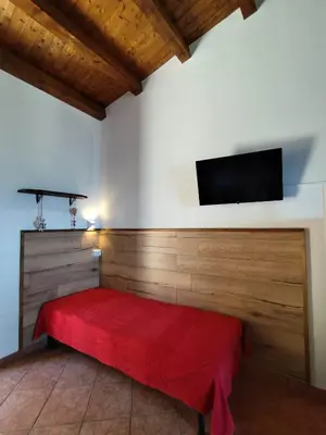 a room with a red bed and a flat screen tv at Open Space Marianna - Sea View in Trabia