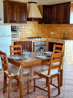a kitchen with a wooden table with glasses on it at Open Space Marianna - Sea View in Trabia