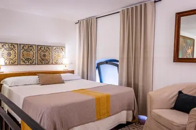 a bedroom with a bed and a chair and a window at Resuttano Loft in Palermo
