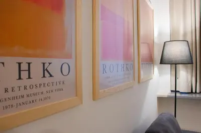 three posters on a wall next to a lamp at Resuttano Loft in Palermo