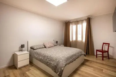 a bedroom with a bed and a chair and a window at Villareale Flat - Palermo City Center Free Parking in Palermo