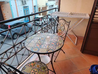 a table and chairs sitting on a balcony at Conchiglia azzurra in Trappeto