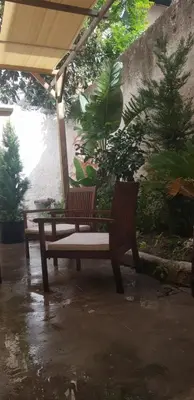 two wooden benches sitting under an umbrella at Baglio porta d Ossuna in Palermo