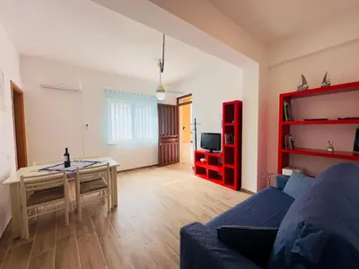 a living room with a blue couch and a table at Balestrate Mare Centro Wi-Fi Self Check-in Aria Condizionata in Balestrate