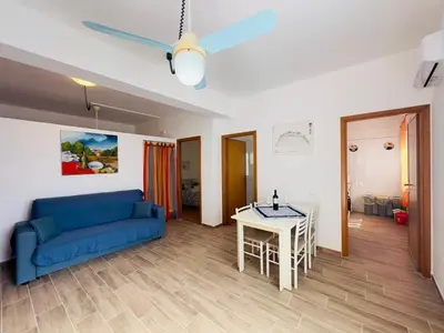 a living room with a blue couch and a table at Balestrate Mare Centro Wi-Fi Self Check-in Aria Condizionata in Balestrate