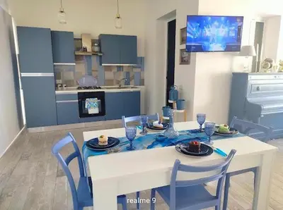 a kitchen with a table and chairs and a dining room at Parco della Vittoria in Terrasini